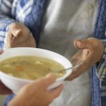 Hands of Homeless Man Receiving Bowl of Soup --- Image by © Royalty-Free/Corbis